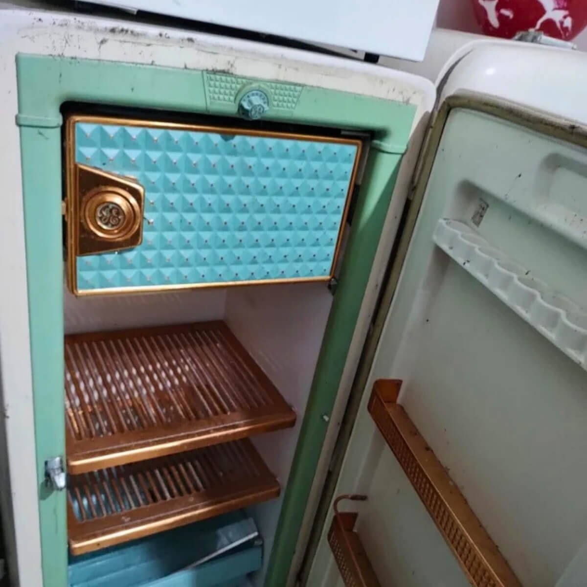 Geladeira antiga estilo vintage aberta após manutenção técnica, demonstrando atendimento a modelos clássicos.