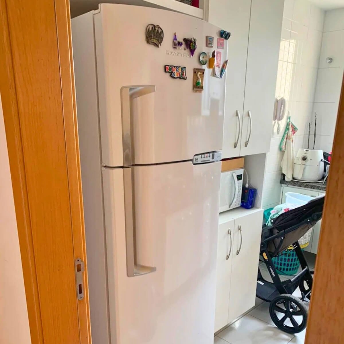 Geladeira doméstica branca duplex Consul em cozinha planejada após conserto em domicílio em Curitiba.